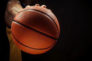 silhueta-vista-de-um-jogador-de-basquete-segurando-uma-bola-de-basquete-em-fundo-preto_155003-11454-1
